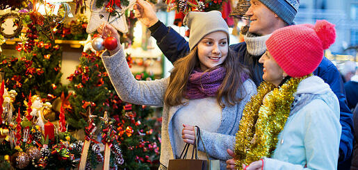 Happy,positive,family,of,three,at,christmas,market.,selective,focus
