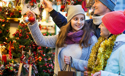 Happy,positive,family,of,three,at,christmas,market.,selective,focus